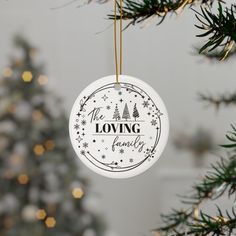 a white ornament hanging from a christmas tree with the words loving family printed on it