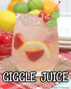 a close up of a drink in a glass on a table with fruit behind it