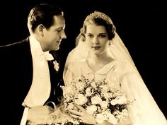 an old photo of a bride and groom looking at each other while posing for the camera