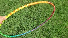 a person is holding a colorful hula hoop in the grass