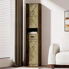 a white couch sitting next to a tall wooden cabinet in the corner of a room