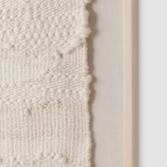 a close up of a piece of art with white yarn on the bottom and sides