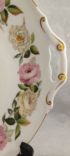 a white and gold plate with flowers on it