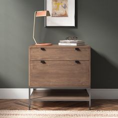 a wooden dresser with two drawers and a lamp on top