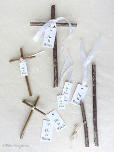 the cross is made out of sticks with tags attached to it and tied in twine