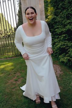 a woman in a white dress posing for the camera