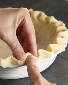 a person placing an uncooked pie crust on top of a pie pan with text overlay that reads the ultimate hard pie crust