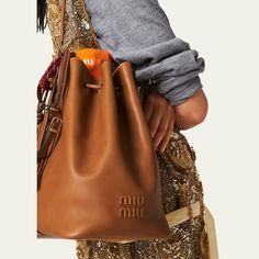 Miu Miu bucket bag in fine calf leather  Adjustable buckle shoulder strap  Drawstring closure  Approx. 11.4"H x 6.7"W x 5.1"D Made in Italy Miu Miu Brown Bag With Detachable Strap, Brown Miu Miu Shoulder Bag With Detachable Strap, Miu Miu Brown Shoulder Bag With Detachable Strap, Elegant Brown Miu Miu Shoulder Bag, Miu Miu Brown Satchel Bag, Miu Miu Satchel With Adjustable Strap, Formal Miu Miu Bags With Adjustable Strap, Miu Miu Formal Bag With Adjustable Strap, Miu Miu Formal Bags With Adjustable Strap