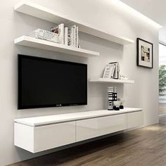 a living room with white furniture and a flat screen tv mounted to the side of a wall