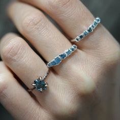 a woman's hand with a ring made out of blue sapphires and diamonds