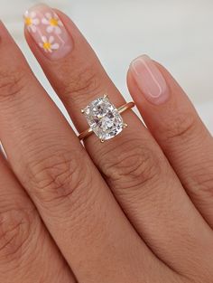 a close up of a person's hand with a ring on it and a flower design