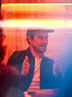 a man sitting at a table talking to someone