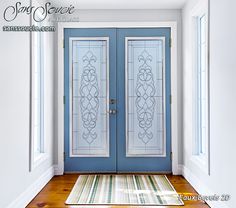 a blue front door with two glass panels and a rug on the floor next to it