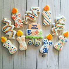 decorated birthday cookies arranged on a white wooden surface