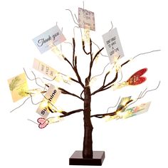 a lighted tree with many cards attached to it