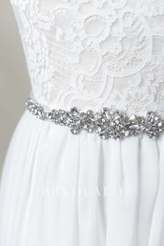 The perfect finishing touch for a wedding gown, this dazzling bridal sash features glittering rhinestones in intricate design is very popular online. content satin, rhinestones, alloy embellished portion length 45cm, width 3cm ribbon length 275cm, width 2cm White Rhinestone Bridal Belt, Bedazzled White Bridal Belt For Wedding, White Rhinestone Sashes For Bridesmaids, White Bridesmaid Sashes With Rhinestones, White Bridesmaid Sash With Rhinestones, Silver Bedazzled Wedding Dress, White Rhinestones Bridesmaid Bridal Accessories, Silver Rhinestone Wedding Dresses, Satin Sash