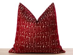 a red pillow sitting on top of a wooden table