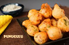 some food is sitting on a black plate and next to a yellow towel with the words puduguli written in it