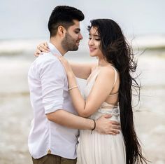 a man and woman embracing each other on the beach