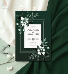 a wedding card with flowers and leaves on the front, in black and white colors