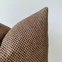 two brown and white checkered pillows sitting next to each other