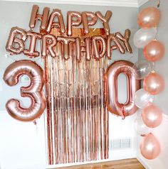 balloons and streamers in the shape of numbers are displayed for a 30th birthday party