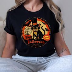 Vintage Retro Halloween Cat t shirt, Nostalgic retro gift for her, Halloween Kitty Cat Lover gift tee for mom 🌟 **Step into the past with our Retro Halloween Cat Unisex Jersey Tee 🌟 Embrace the charm of yesteryear with our  Retro Halloween Cat Unisex Jersey Short Sleeve Tee. This classic tee is not just a piece of clothing; it's a nostalgic journey wrapped in soft cotton and adorned with adorable vintage baby animals. Perfect for all ages, this tee fits like a well-loved favorite and will make you fall in love over and over again. ✨ **Quality You Can Feel Made with 100% Airlume combed and ring-spun cotton, our lightweight fabric (4.2 oz/yd² or 142 g/m²) is a dream to wear. The breathable material is easy to layer, making it ideal for both active and leisure wear. The ribbed knit collars, Retro Halloween T-shirt With Character Print, Halloween Graphic Print Top As Gift, Casual Halloween T-shirt For Gift, Vintage Black Top Gift, Black Vintage Top Gift, Vintage Black Top As Gift, Vintage Halloween T-shirt With Character Print, Novelty Black T-shirt As A Gift, Novelty Black T-shirt As Gift