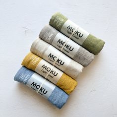 five different colored towels are stacked on top of each other, with the words moku written