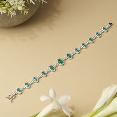 This stunning tennis bracelet is beautifully crafted with vibrant emerald green/ sapphire blue cubic zirconia stones, each meticulously set within a halo of sparkling white CZs. The silver-tone base adds a touch of elegance and durability, making this piece perfect for adding a pop of color to any outfit. Ideal for those seeking a touch of luxury at an affordable price, this bracelet is a must-have accessory for both casual and formal occasions. Enhance your jewelry collection with this exquisite blend of style and sophistication. Guaranteed to arrive looking even more stunning than it does on your computer screen, our jewelry is crafted to impress. **WHY CUBIC ZIRCONIA? Unlike diamonds, cubic zirconia is always flawless. It is a fantastic ethical and cost-effective alternative to diamonds Green Oval Tennis Bracelet As Gift, Green Oval Tennis Bracelet For Gift, Green Oval Diamond Tennis Bracelet, Green Oval Diamond Bracelets, Oval Green Diamond Bracelets, Bracelet Tennis, Birthday Bracelet, Halo Setting, Green Sapphire