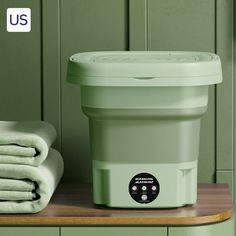 a green container sitting on top of a wooden counter next to towels and a towel dispenser