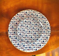 a white and blue plate sitting on top of a wooden table