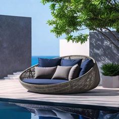 a couch sitting on top of a pool next to a tree