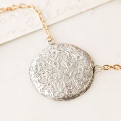 This one-of-a-kind necklace is composed of: Victorian, sterling silver dress pin from the late 1800s with hand-engraved scrollwork and ivy design details on the front. This piece was originally made sourced in England. This necklace measures a standard 18” on a modern 14k gold filled chain. The pendant measures 1" in width. White Gold Etched Round Pendant Necklace, Etched White Gold Round Pendant Necklace, Antique White Gold Necklace With Filigree, Antique White Gold Filigree Necklace, Antique White Gold Necklace With Intricate Design, Medallion Etched Necklace For Anniversary, Etched Medallion Necklace For Anniversary, Anniversary Etched Medallion Necklace, Silver Brass Jewelry With Engraving Option