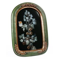 an ornate frame with flowers and leaves painted on the glass in gold trimmings