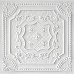 a white ceiling tile with an ornate design on the center and bottom part of it