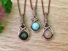 "Each necklace features your choice of crystal that is hand wire wrapped with antiqued copper wire. The pendant has a larger crystal focal bead that is accented with a smaller crystal bead. They measure about 1 1/2\" x 2/3\" and hang on an antiqued copper chain necklace in your choice of length (15\"-30\"). Please choose the crystal combo you would like from the drop down menu. The choices are as follows: *Green Moonstone with Sunstone* *Peach Moonstone with Amethyst* *Golden Sheen Obsidian with Bohemian Style Wire Wrapped Necklace, Nature Jewelry Aesthetic, Wire Wrapped Teardrop Pendant, Diy Wire Necklace Pendant, Wore Wrapped Crystal, Wire Wrapped Polymer Clay Jewelry, Wire Wrapped Coffin Stone, Simple Wire Pendant, Wire Jewelry Pendant