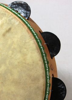 a close up of a musical instrument with black knobs and green band around the top