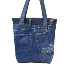 a denim bag with holes on the side and zippers at the bottom, sitting on a white surface