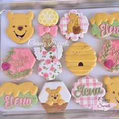 a box filled with lots of decorated cookies in the shape of winnie the pooh