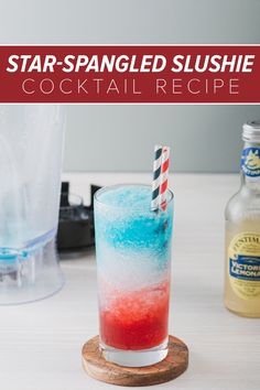 a red, white and blue drink sitting on top of a wooden coaster next to a bottle