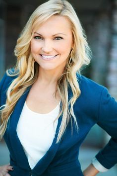 a woman with long blonde hair wearing a blue blazer and white t - shirt