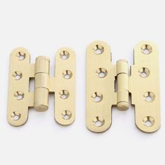 three brass plated door hinges with holes on each side and one missing