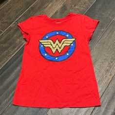 Gently Loved In Excellent Condition. It’s Possible This Was Never Worn. Brand: Wonder Woman Girls Graphic Tee Red, Blue, & Gold Wonder Woman Symbol Gold Part Is Glittery Cap Sleeves 50% Cotton/50% Polyester Size L (10/12) At-3 Themed Red Short Sleeve Tops, Red Themed Short Sleeve Tops, Superhero Cartoon Print Cotton T-shirt, Superhero Cotton Tops With Cartoon Print, Superhero Cartoon Print Cotton Tops, Red Superhero Short Sleeve Top, Red Themed T-shirt With Cartoon Print, Themed Red T-shirt With Cartoon Print, Red Themed Cartoon Print T-shirt