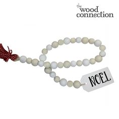 a white beaded necklace with a red ribbon on it and a tag that says wood connection