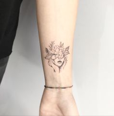 a woman's arm with a flower tattoo on the left side of her wrist