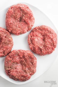 three hamburger patties on a white plate