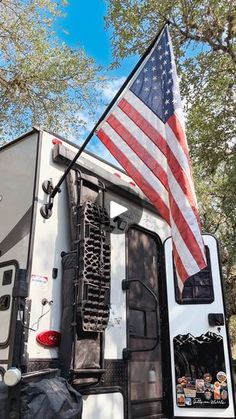 an american flag is attached to the back of a camper