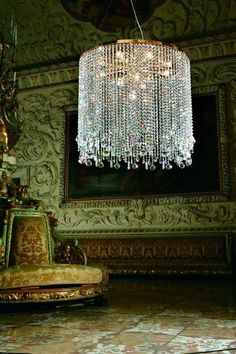 a chandelier hanging from the ceiling in a room with ornate walls and flooring