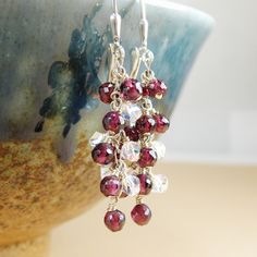 Flirty and sophisticated garnet dangle earrings are handmade with small natural garnet gemstones finely faceted for added sparkle and clear Swarovski crystals cascading down a sterling silver chain. Give a January born girl a unique and artisan gift which she can dress up in. Garnet is the birthstone for January born women. Earrings Details: - Garnet earring length is 1.75 inches  (4.45 cm) with the earrings closures - Sterling silver wire, chain and leverback findings. Available in gold filled. - Garnet earrings will arrive carefully packaged in a jewelry box with a ribbon Fine Heart jewelry are always handmade and custom fitted.  - Customize the earring findings; please use the drop down menu - Choose your metal preference; available sterling silver (shown) and gold filled LOVE garnets? Elegant Faceted Garnet Earrings, Garnet Faceted Earrings For Gift, Sterling Silver Faceted Beads Earrings For Gift, Sterling Silver Earrings With Faceted Beads For Gifts, Garnet Faceted Drop Earrings, Faceted Garnet Drop Earrings, Faceted Beads Briolette Earrings For Gift, Faceted Briolette Beads Earrings For Gift, Briolette Faceted Beads Earrings As Gift