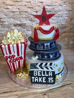 a three tiered cake decorated with popcorn, film strips and a red star on top